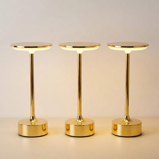 Cordless touch table lamp in gold against a plain off white wall