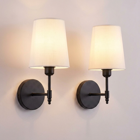 Fabric shade battery sconce in matte black on a pale bone wall