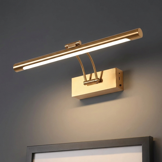 16 inch cordless picture light in brushed brass gold, lit, mounted on a deep charcoal wall